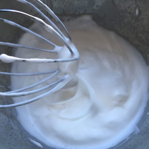 Whipped aquafaba in the bowl of a stand mixer