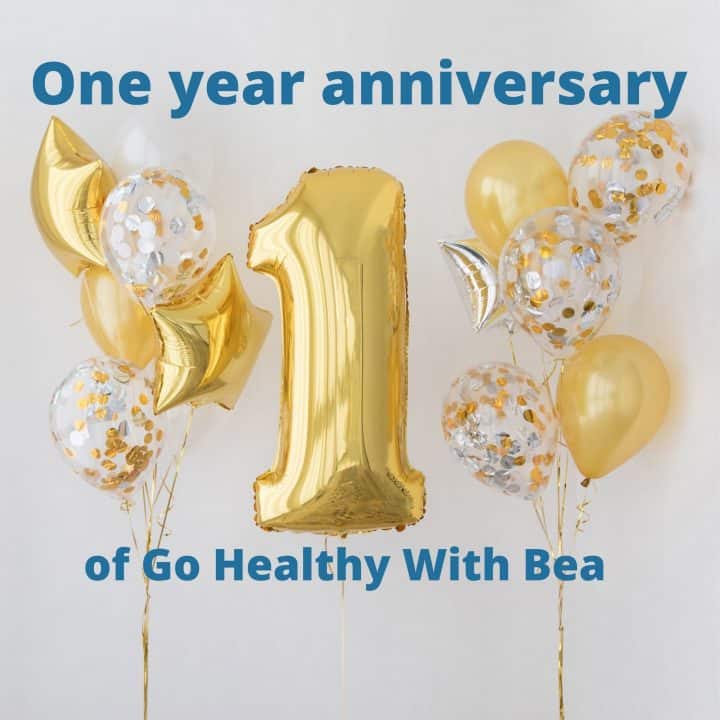 a graphic with gold balloons and the title "one year anniversary" written