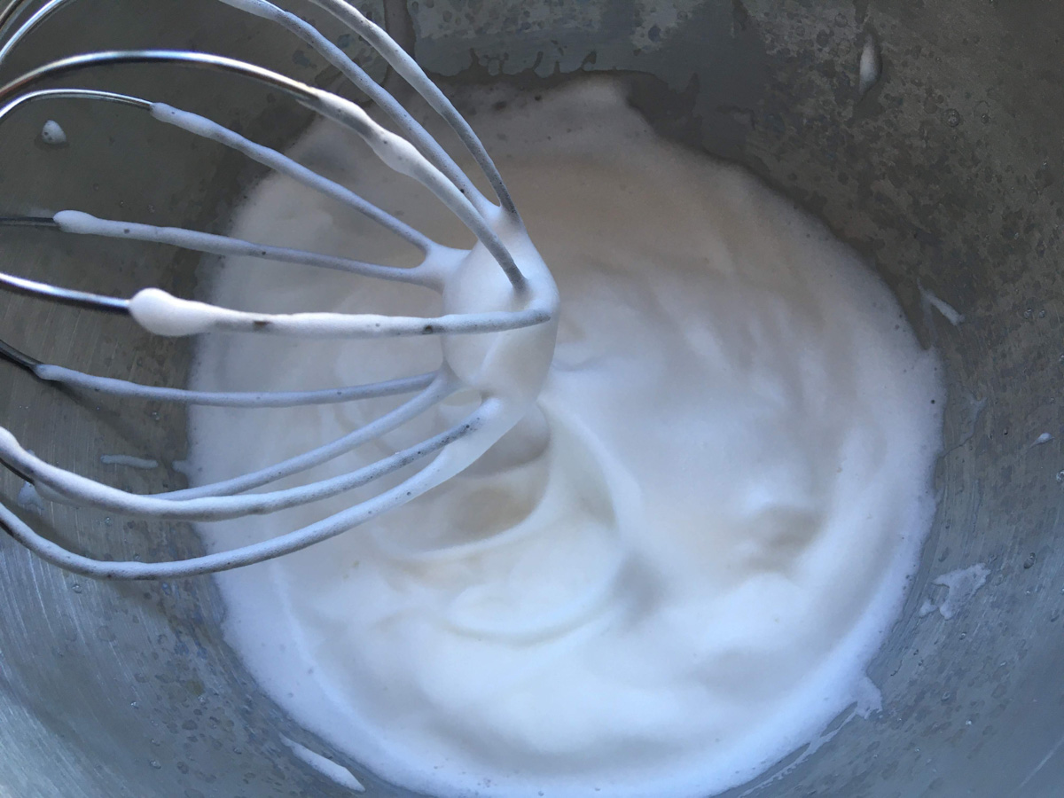 Whipped aquafaba in the bowl of a stand mixer