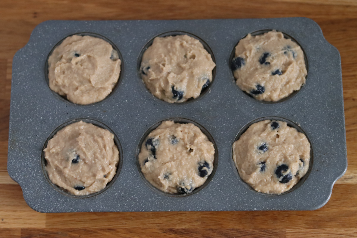 banana blueberry muffins batter in a muffin pan