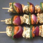 3 chicken kabobs on a black tray