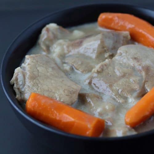 veal blanquette with 3 carrots in a large black serving bowl