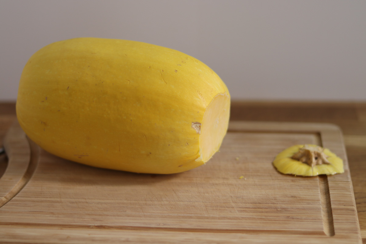 spaghetti squash with the top cut off on a wooden board