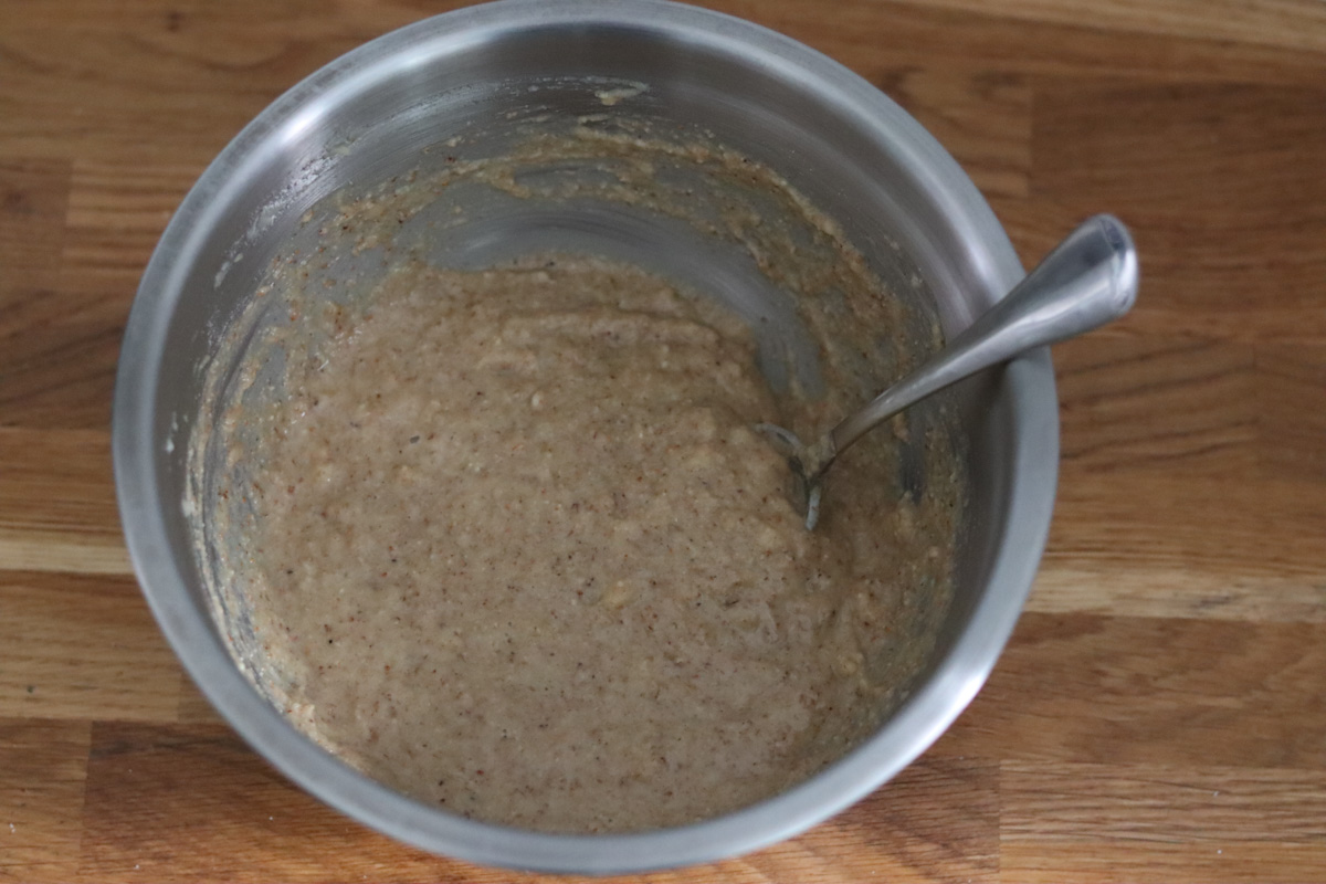 banana bread batter in a mixing bowl with a spoon