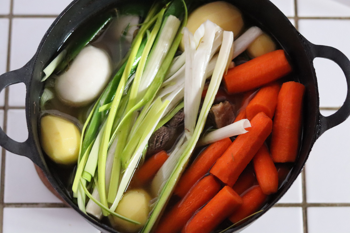 vegetables added in the dutch oven on top of the beef 