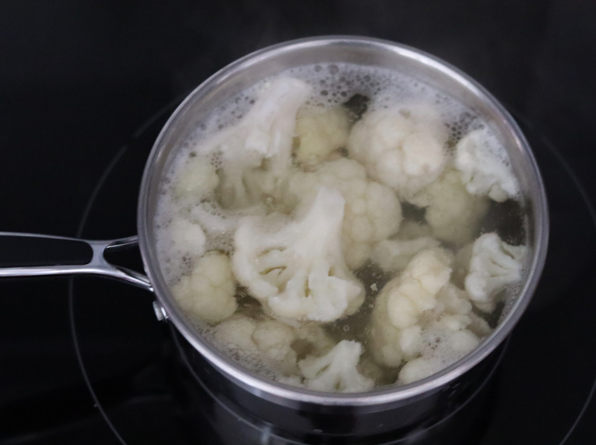 cauliflower florets cooking in boiling water in a sauce pan