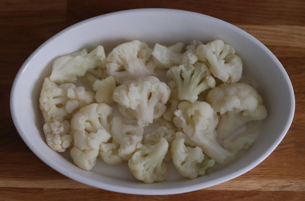 cauliflower florets in a white baking dish