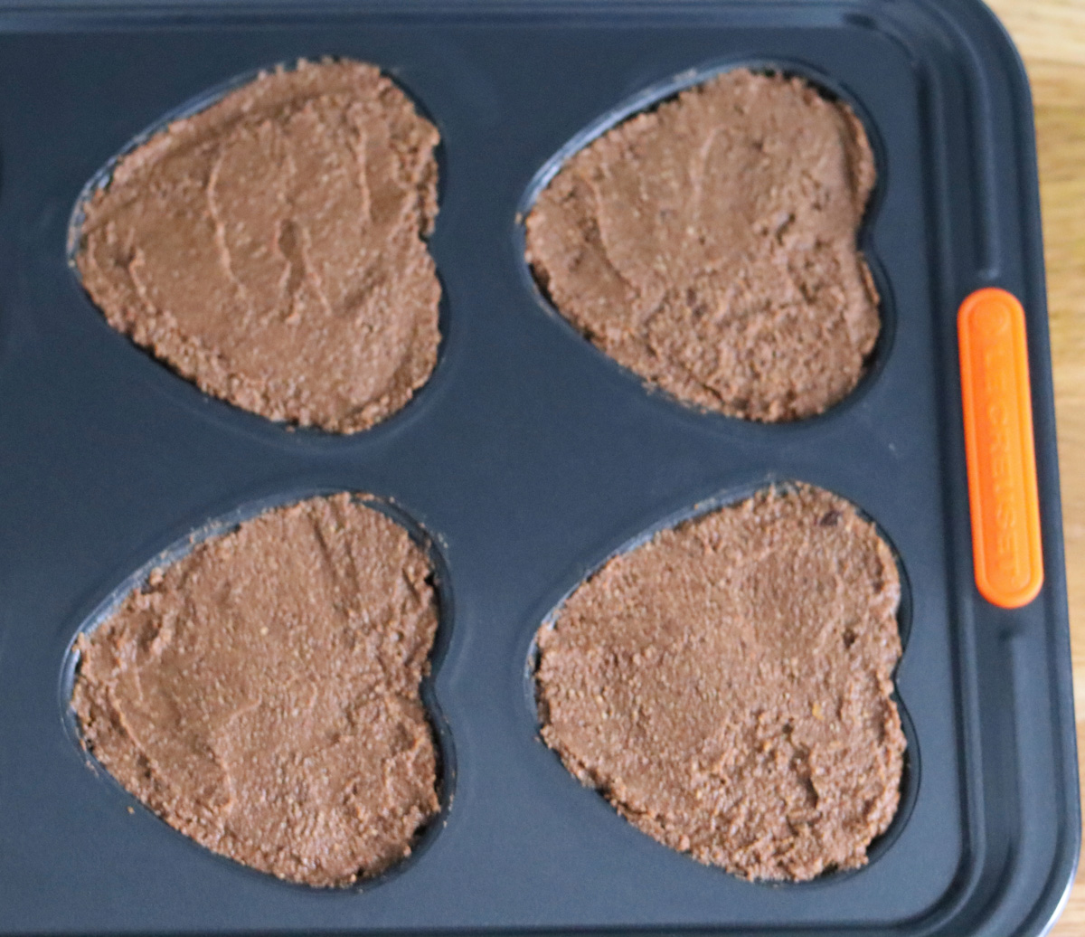 the cake batter in a heart shaped muffin pan