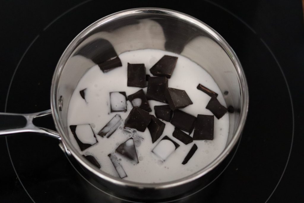 lait de coco et carrés de chocolat dans une casserole sur une plaque à induction