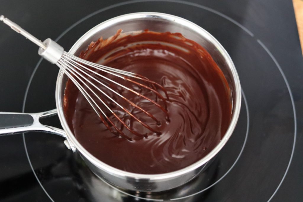 chocolat fondu dans une casserole et un fouet qui vient de mélanger le tout
