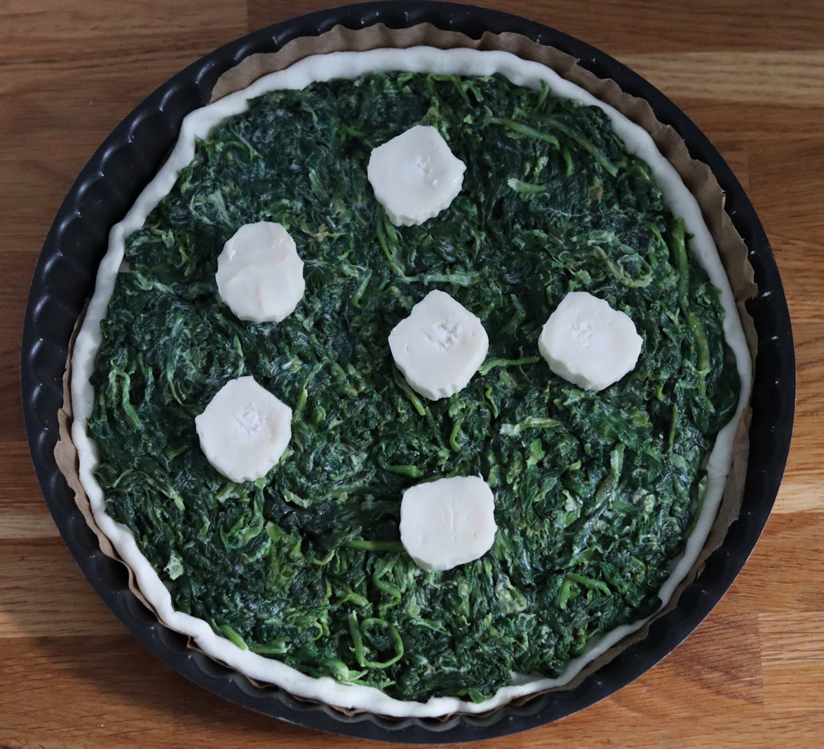 spinach and goat cheese tart with 6 goat cheese log slices on top