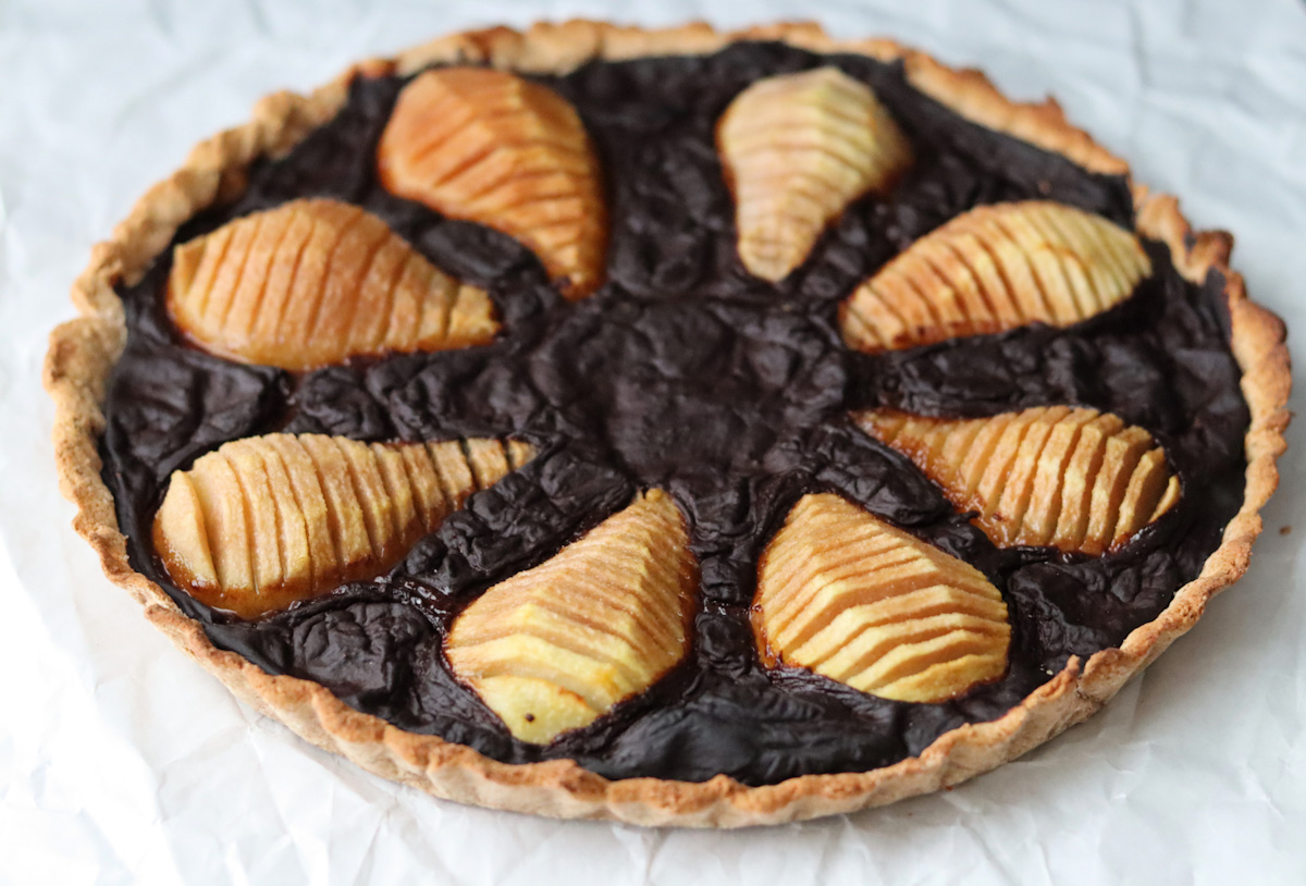 a pear and carob tart on a white sheet 