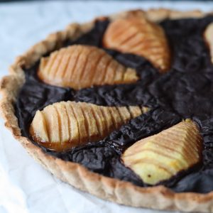 a pear and carob tart on a white sheet