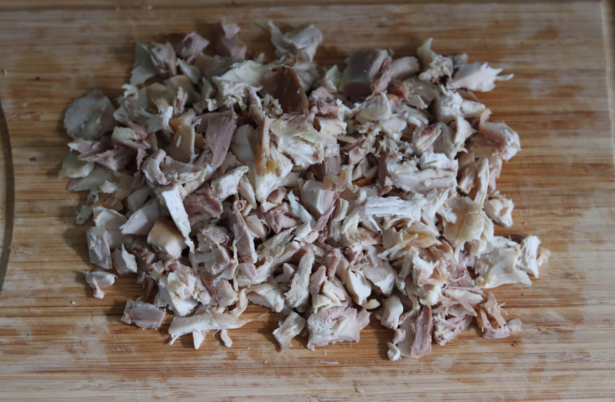 shredded leftover roasted chicken on a wooden board