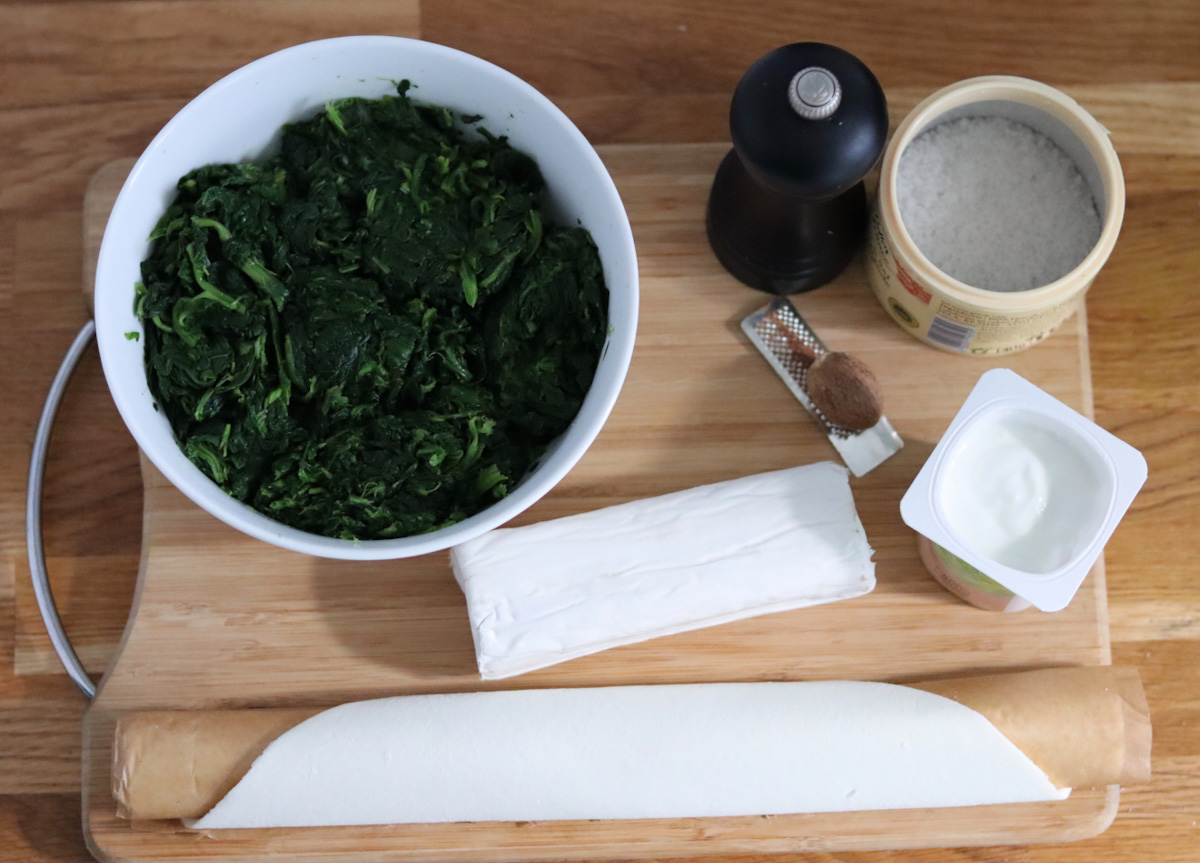 all the ingredients for the spinach and goat cheese tart displayed on a kitchen counter