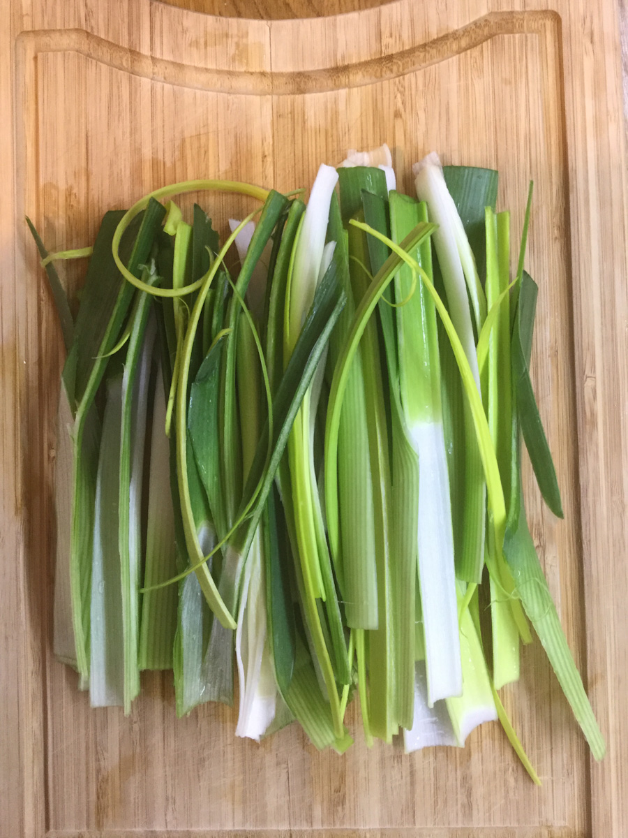 cleaned and cut leeks on a wooden board