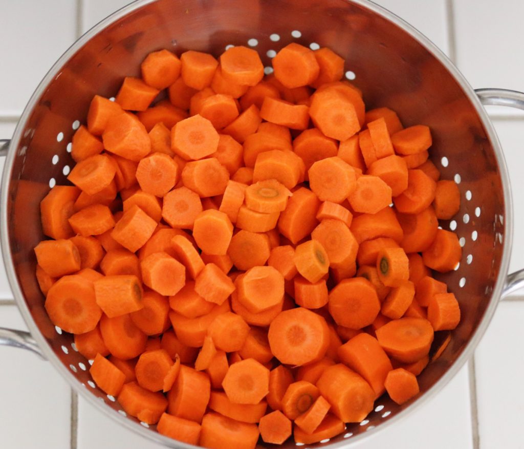 peeled and sliced carrots in a strainer