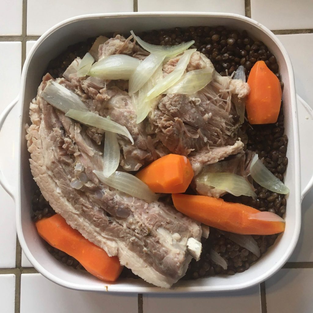 petit salé aux lentilles et carottes dans un plat blanc