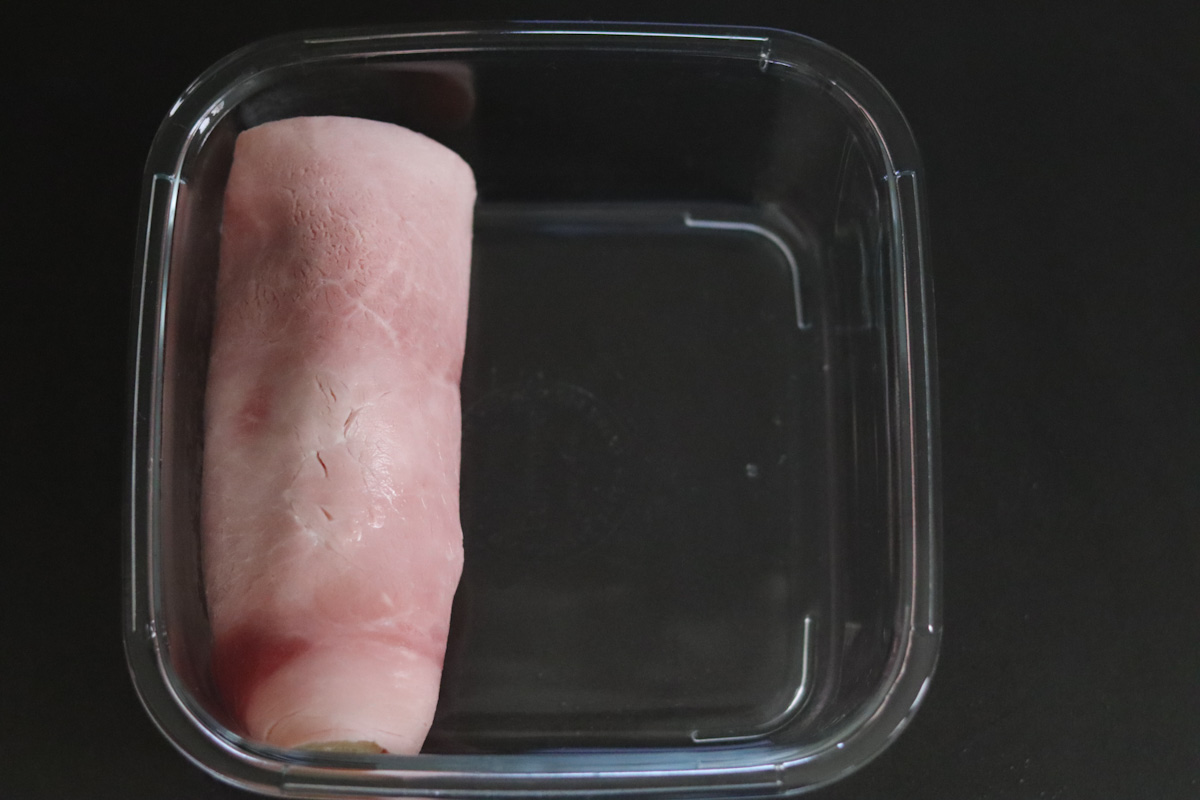 an endive rolled in a piece of ham in a baking dish