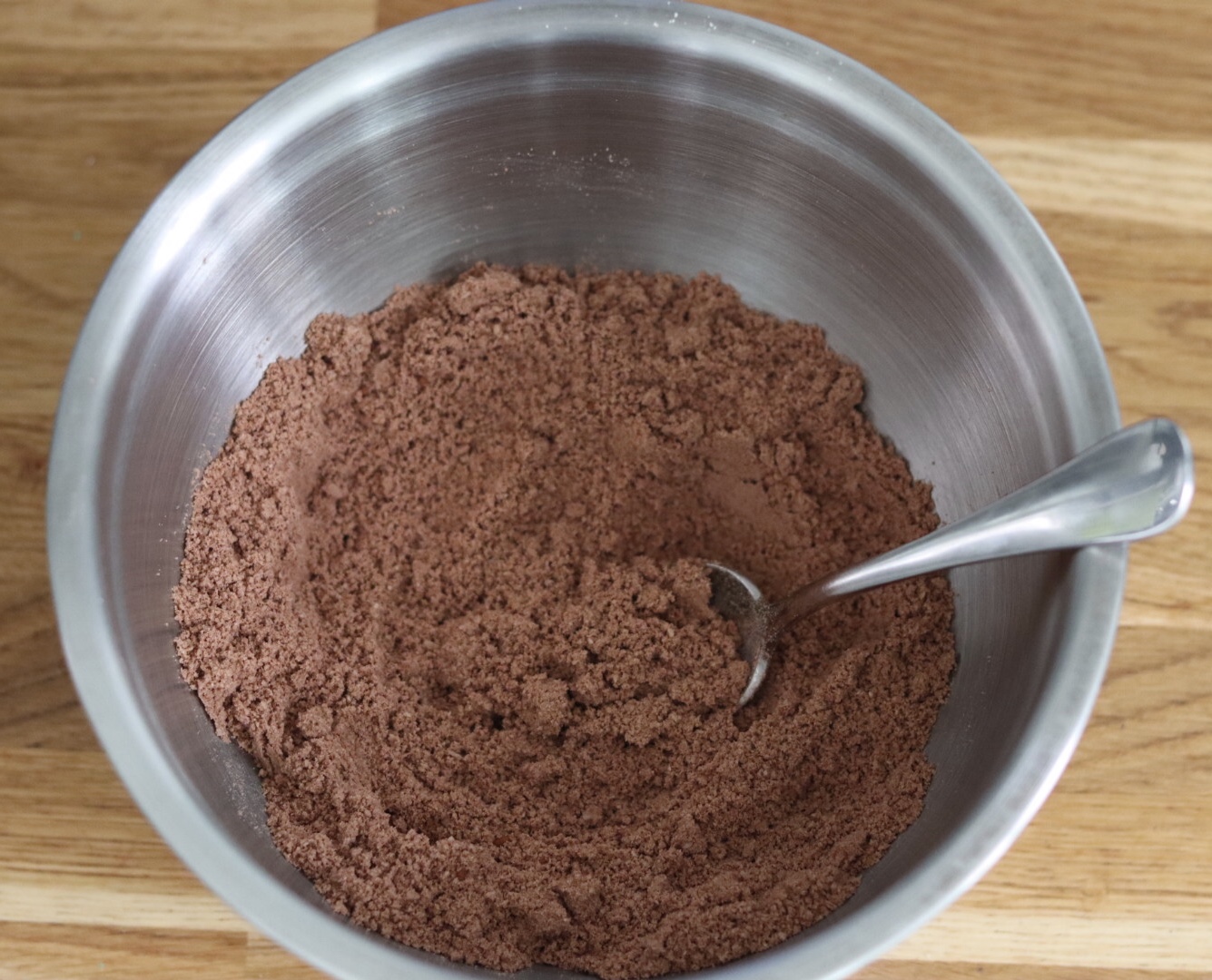 chocolate zucchini bread dry ingredients mixed in a large bowl with a spoon