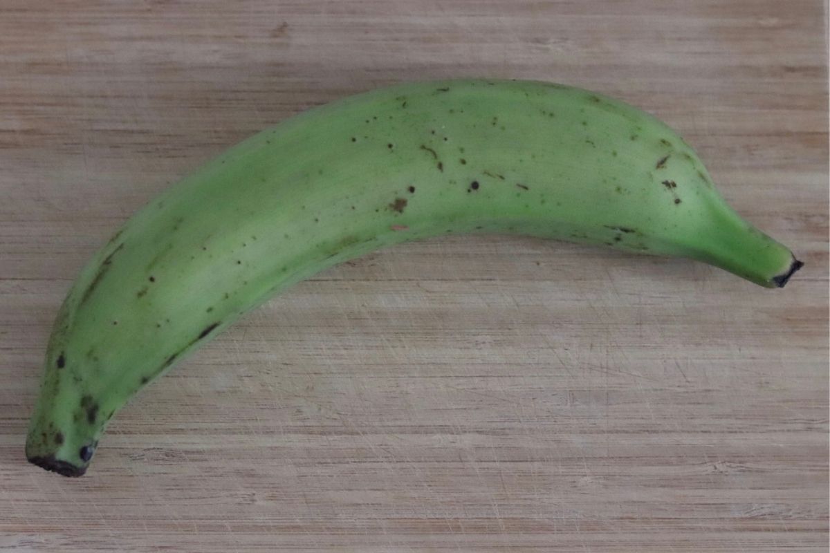 banane plantain verte sur une planche à découper