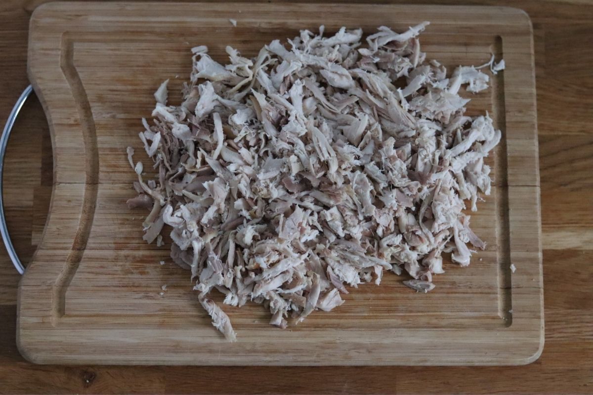 Shredded chicken on a wooden cutting board