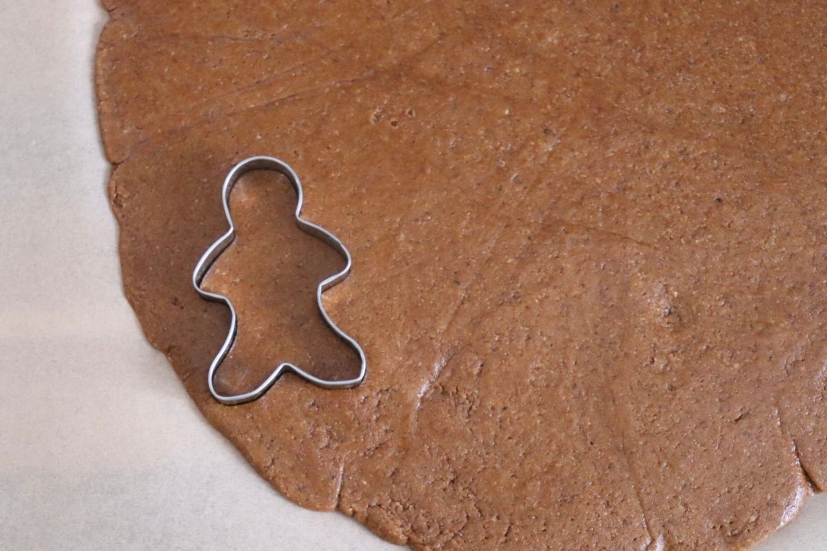 a gingerbread man being cut out in the dough