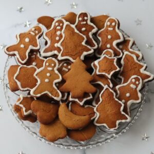 a plate full of gingerbread cookies on a table decorated with silver stars