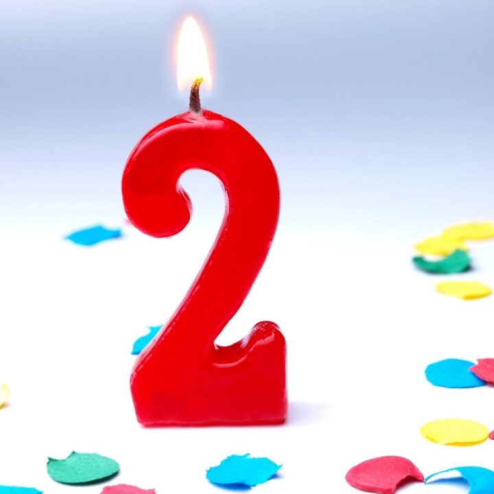 a picture of a red number 2 candle and some colored confetti