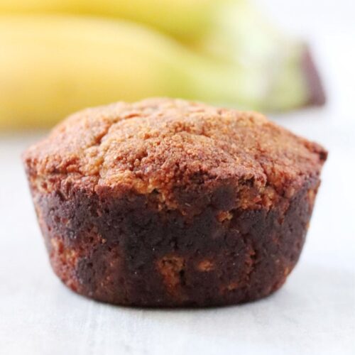 a banana bread muffin in front of 2 blurry bananas
