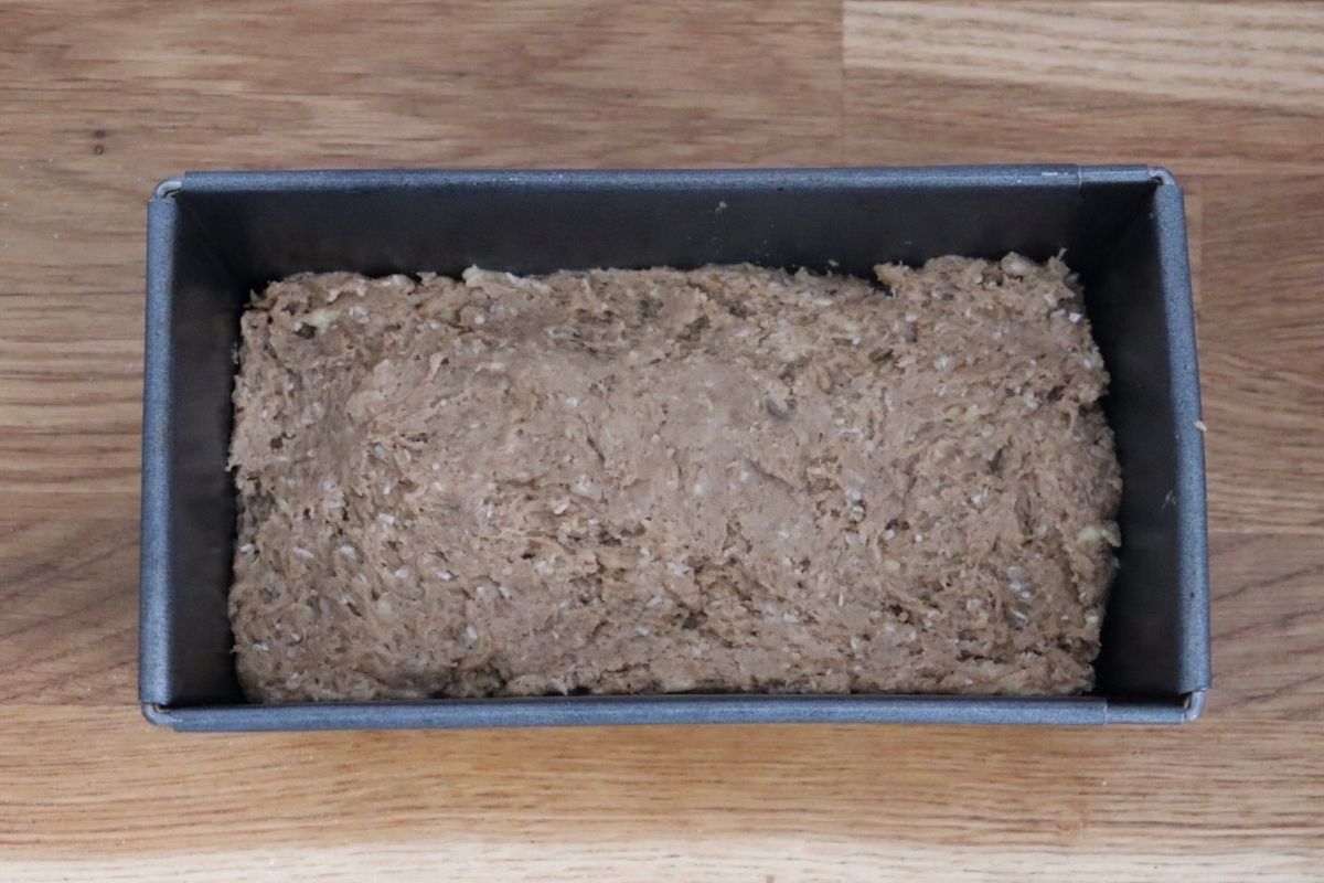 banana bread dough in a rectangular tin, ready to be put in the oven