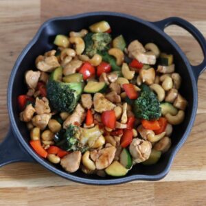 chicken stir fry in a cast iron skillet on the kitchen counter