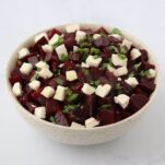 beetroot and feta cut in cubes in a large bowl with chopped parsley on top