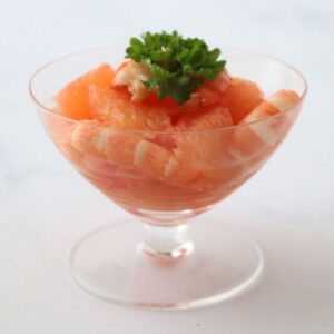 salade de crevette et pamplemousse rose dans une coupe avec des feuilles de persil pour décorer