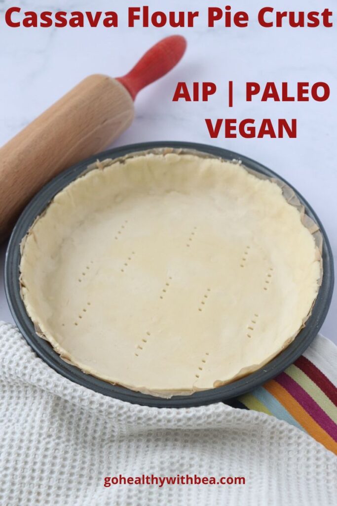 a pie crust in a pie tin with a table cloth and a rolling pin on the side