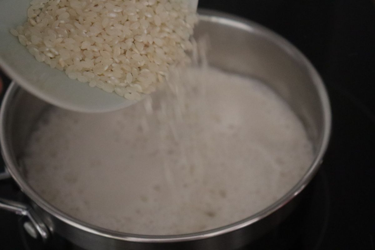 a bowl of rice being poured in boiling dairy free milk