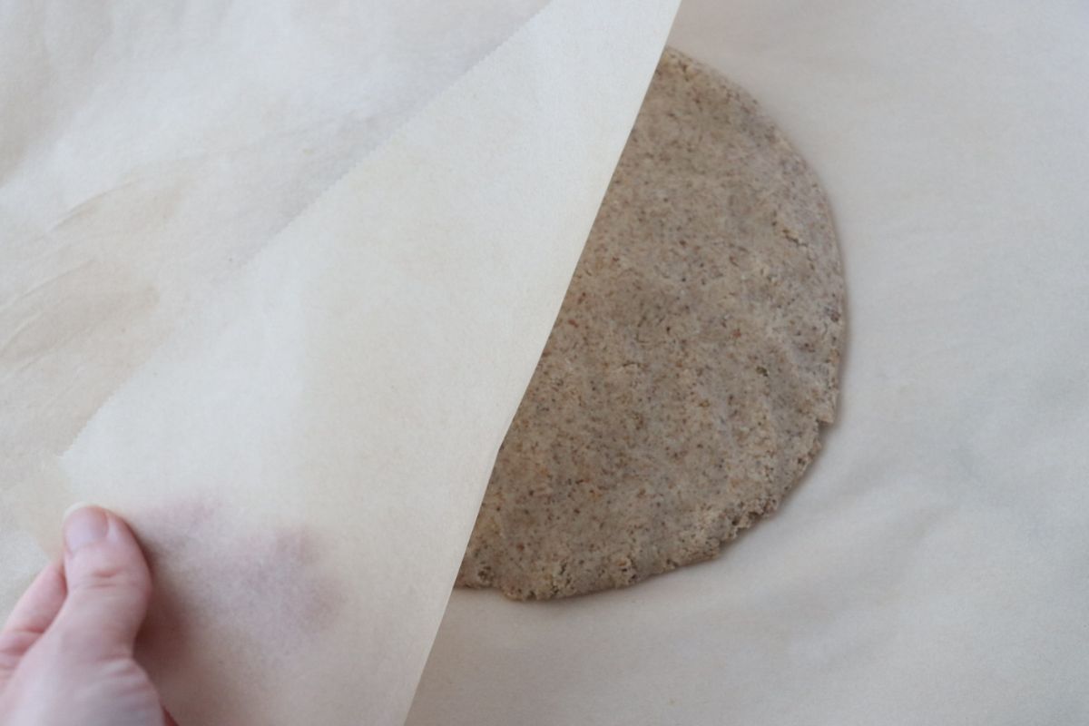 a flattened dough between 2 parchment papers