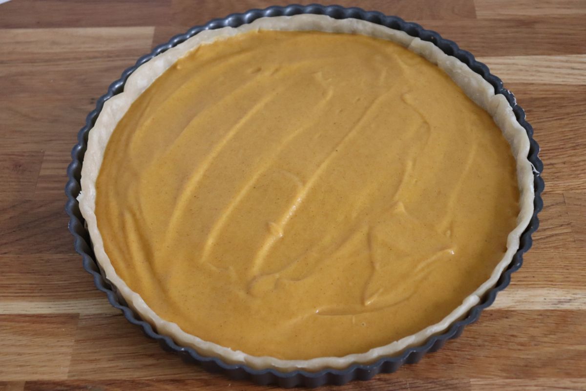pumpkin pie filling spread on the pie crust