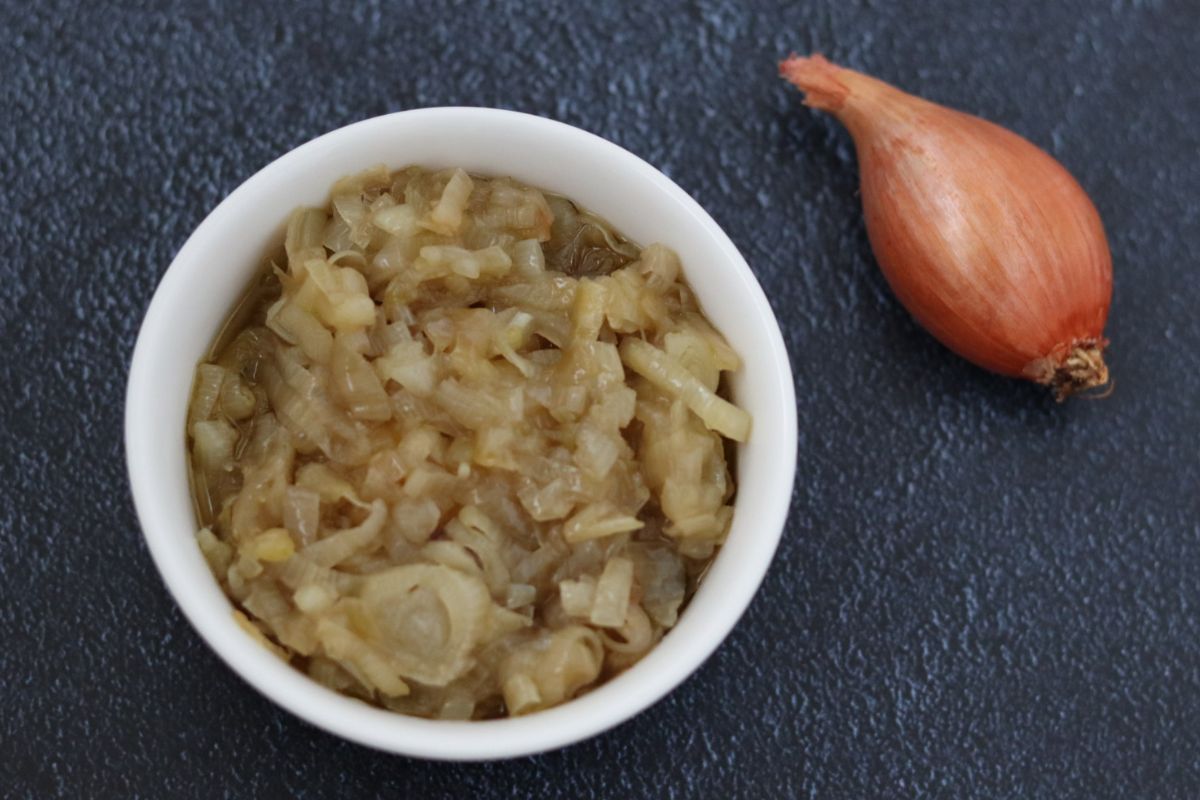 shallot sauce in a small white bowl and a shallot on the side