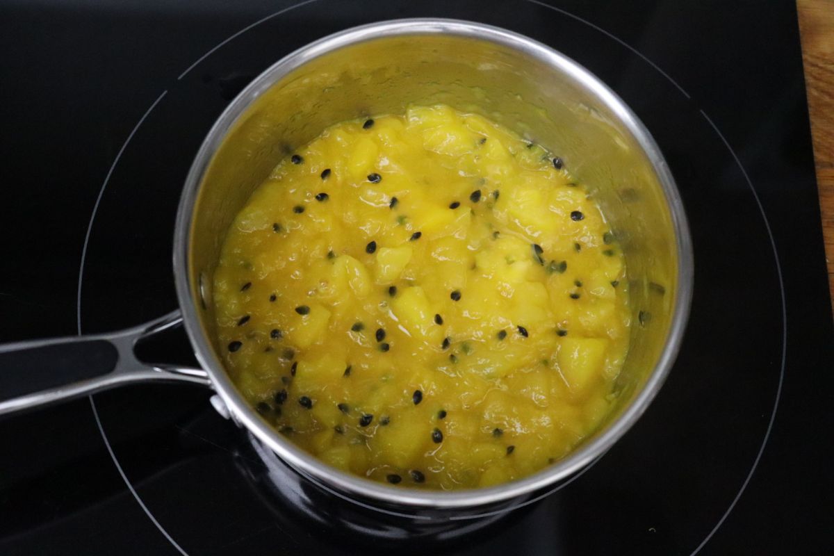 Compote de mangue et fruits de la passion dans une casserole.