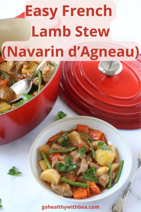A plate of French Lamb Stew Navarin next to the cast iron Dutch oven where it was cooked with a text overlay with the recipe title.