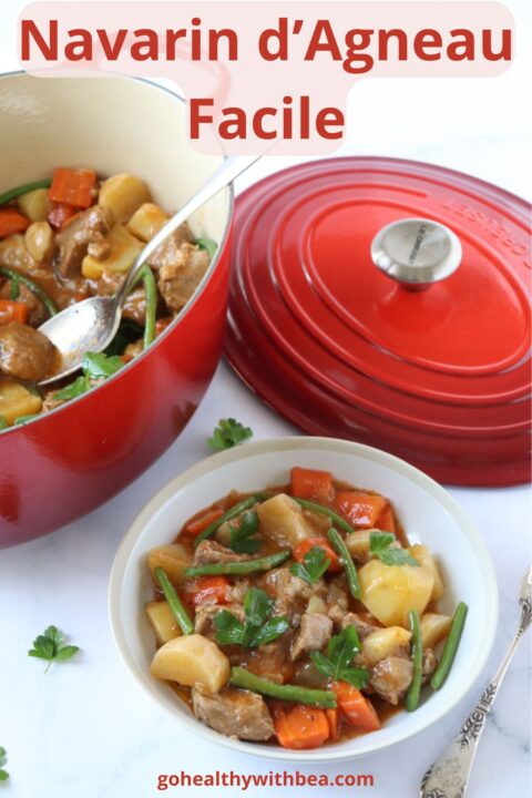 Une assiette de navarin d'agneau à côté d'une cocotte en fonte pleine de navarin.